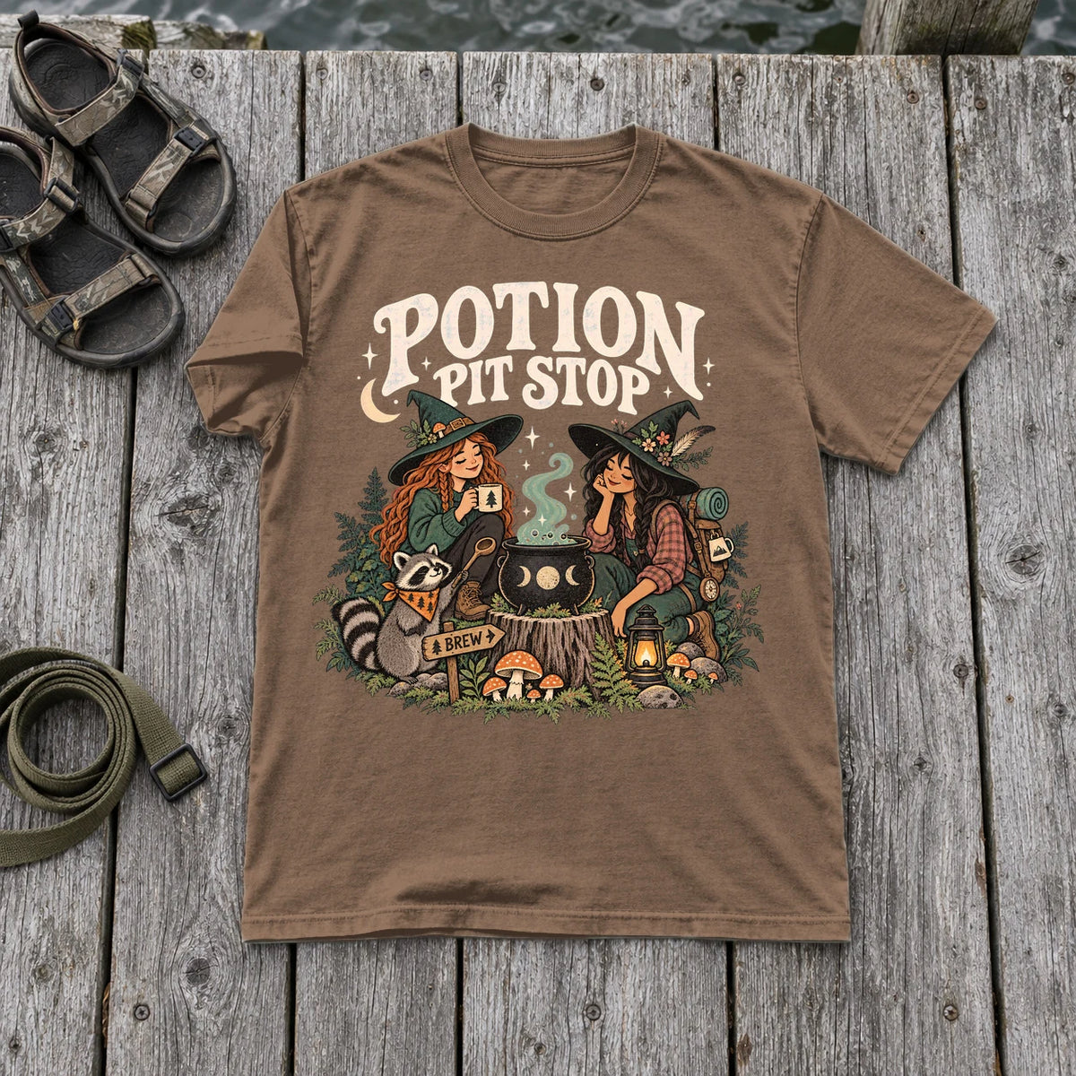 Potion Pit Stop Cozy Witch Graphic Tee on Espresso Premium Tee