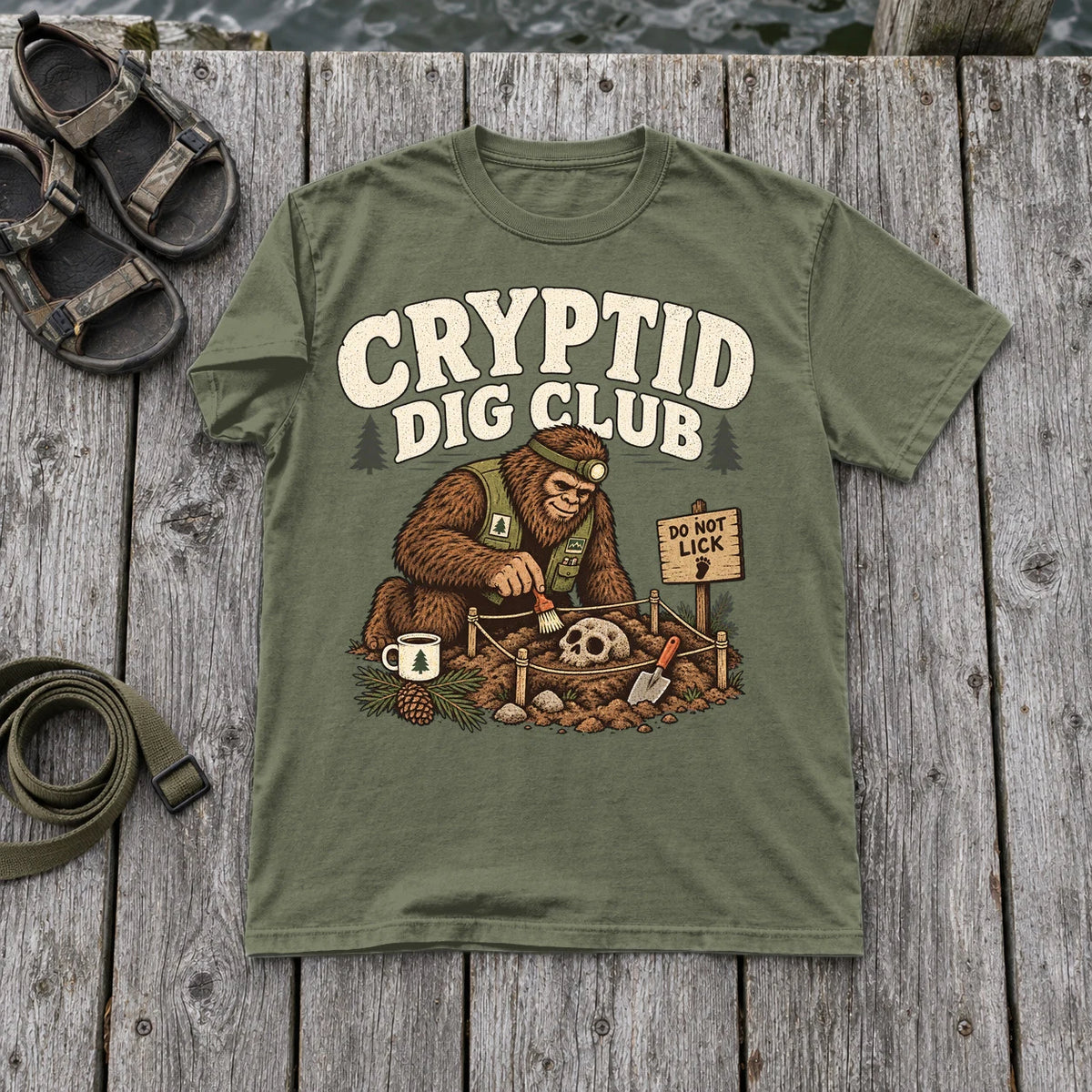 Cryptid Dig Club Graphic Tee on Moss Premium Tee