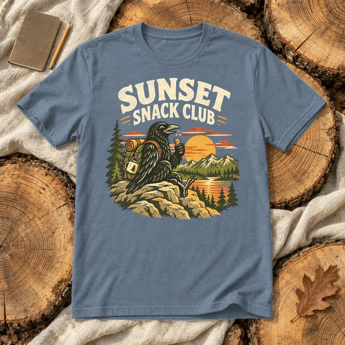 Sunset Snack Club Raven Graphic Tee on Heather Indigo Everyday Soft Tee