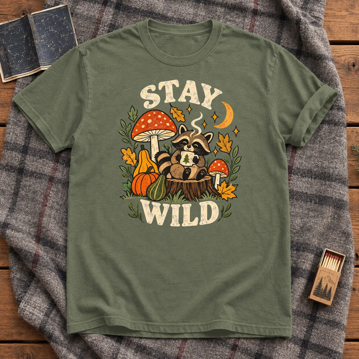 Cozy Autumn Raccoon Stay Wild Graphic Tee on Moss Premium Tee