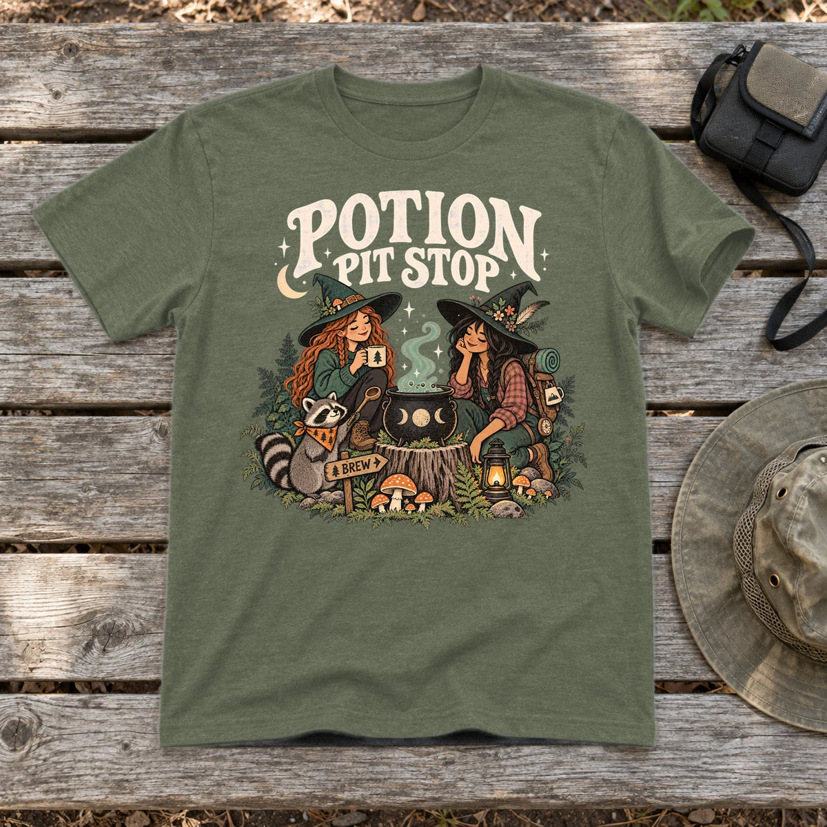 Potion Pit Stop Cozy Witch Graphic Tee on Military Green Everyday Soft Tee