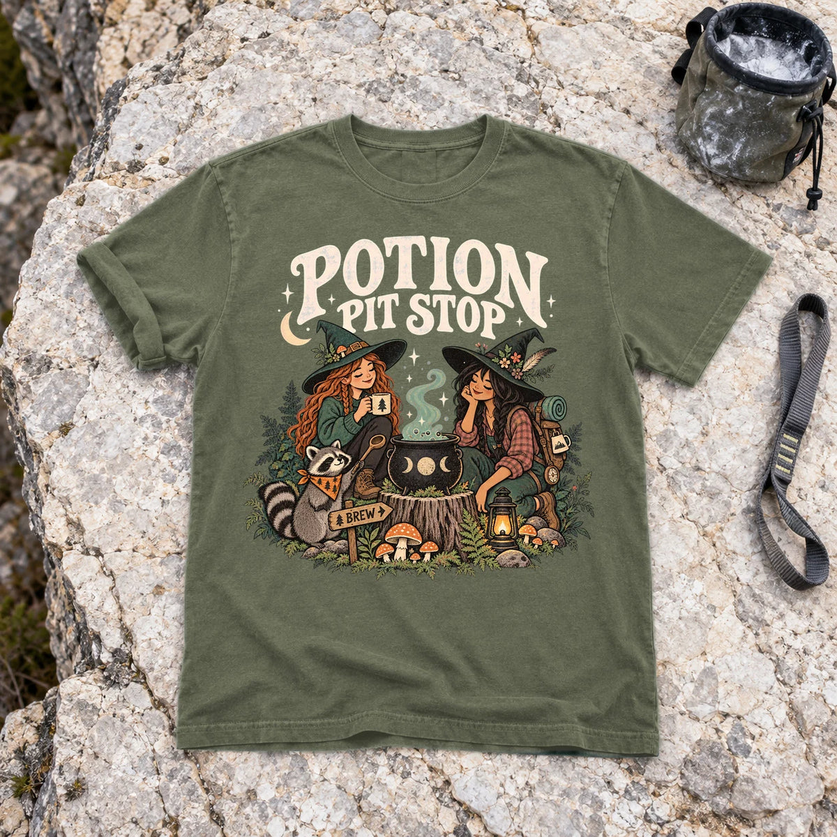 Potion Pit Stop Cozy Witch Graphic Tee on Moss Premium Tee